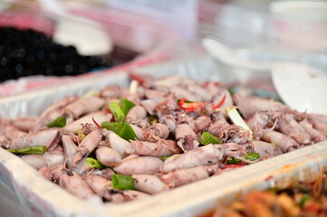 You'll find a variety of ready-to-eat foods at the traditional market food stalls. One beloved option is the stir-fried squid depicted in the photo.