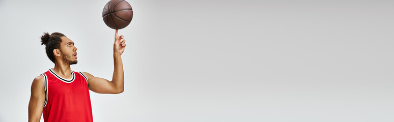 appealing athletic african american man in sportwear playing basketball on gray background, banner