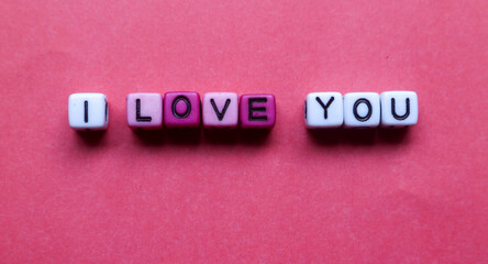 Dice with the words I Love You isolated on red background with love. Concept of Valentine's Day.