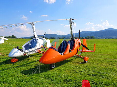 Two autogyro gyrocopter. Small plane in the meadow against the background of the mountains