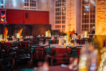 Riga, Latvia - February 16, 2024 -  an event setting with festively lit tables, glowing candles, and a warm, inviting atmosphere in an elegant brick venue