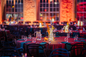 Riga, Latvia - February 16, 2024 - a festive event setting with tables, glowing centerpieces, and illuminated brick walls.