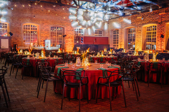 Riga, Latvia - February 16, 2024 -  an elegantly set event space with tables, chairs, and decorative lighting in a rustic brick venue.