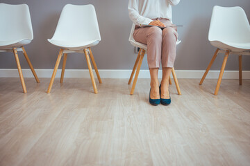 Businesswoman waiting for job interview. Stressful young woman waiting for job interview. Studio...