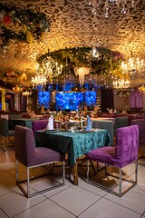 Elegant restaurant interior with purple chairs and green tablecloths
