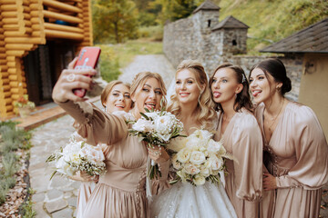 Wedding photography. A blonde bride in a white dress holds a bouquet and takes a selfie