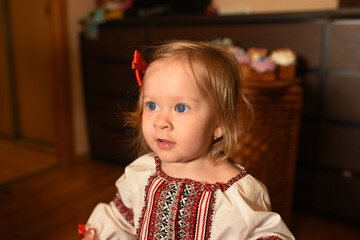A beautiful little girl in a Ukrainian dress. Child eats Easter cakes
