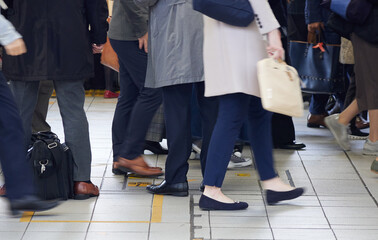 冬の朝の混雑している通勤電車の駅のホームの乗客の様子