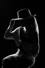 Dark studio portrait of young elegant sexy woman with a white hat and white shirt black and white photo