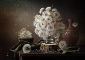 Modern still life with a bouquet of fluffy dandelions on a dark background