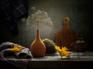 Autumn still life with a dry branch in a clay vase on a dark background