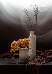 Modern still life with dried hydrangea in a vase on a dark background