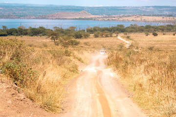 A safari vehicle on a dirt road in the wild at Lake Nakuru National Park in Kenya