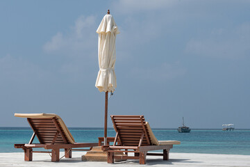 sun loungers on a beach in the Maldive Islands looking out over the Indian Ocean