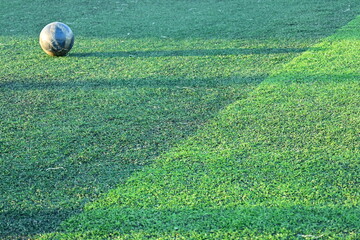 artificial green grass soccer field with blue training ball