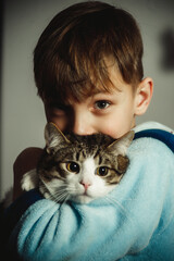 boy with a cat in his arms close-up