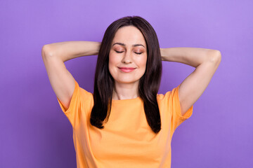 Portrait of satisfied girl with stylish hair wear oversize t-shirt holding arms behind head close eyes isolated on violet color background