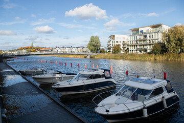 small white yachts moored to the river bank in the city in Stockholm Sweden