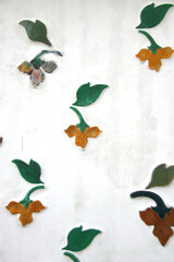 Flowers and leaf on white wall of history site in temple, native ancient art in Bangkok,Thailand.