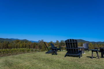 Black Adirondack Chairs on Green Grass Outdoors in the Mountains