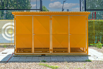 Yellow gas storage cabinet with ventilated sides outside on a field