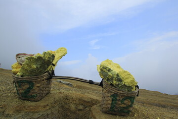 Sulfur stone is placed in a basket to be transported by miners in Ijen Crater, East Java