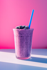 Blueberry smoothie on a pink and white background.