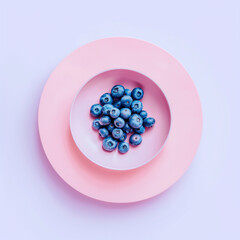 Blueberries in a pastel pink bowl on pastel purple background. Minimal concept. Flat lay.