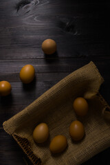 Stack of eggs in the basket on rustic wood background.