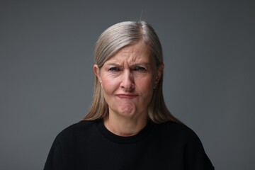 Personality concept. Portrait of emotional woman on gray background