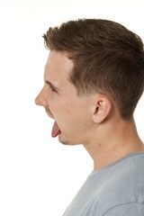 Obraz premium young man shows her toung, feels disgust on white background.