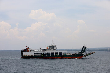 Ferries sail on the sea, ferries in the Bali Strait as a means of transportation between islands in Indonesia. inter-island logistics and economic crossing and shipping modes.