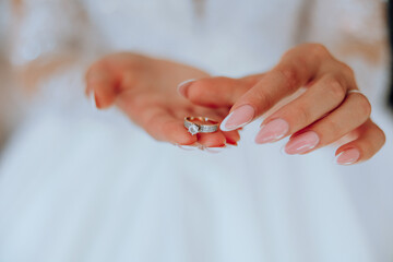 Close-up of an elegant diamond ring on a woman's finger with a modern manicure, sunlight. Love and wedding concept. Soft and selective focus.