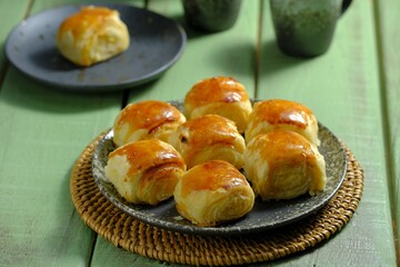 A plate of Bakpia tape, traditional snack from Yogya on green background. Made from cassava fermented, flour, butter abd sugar. Bakpia tape