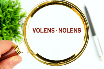 Willy - nilly latin expression volens-nolens (willing or unwilling) written through a magnifying...
