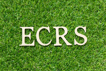 Wood letter in word ECRS (Abbreviation of Eliminate, Combine, Rearrange, and Simplify) on green grass background