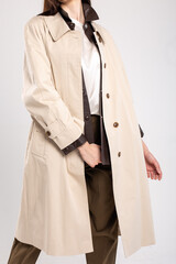 Stylish beige trench coat with brown leather trim and collar