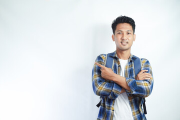 Cheerful Asian male student wearing casual clothes and backpack glasses pointing finger and palm at empty space isolated on white background. high school university college concept