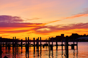 Golden Hour Sunset Over Calm Lake with Silhouetted Dock