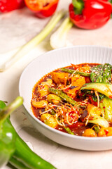 Bowl of red curry with vegetables and tofu on white background
