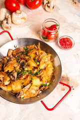 Pan-fried potatoes with mushrooms and onions in a frying pan