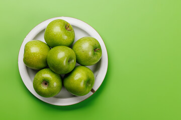Plate with fresh green apples