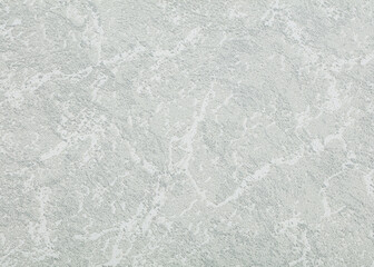 Background of gray paper wallpaper or plastered wall with uniformly chaotic texture.