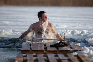 A man bathes in an ice hole on the Orthodox feast of the Epiphany.  Plunge into the icy water.
