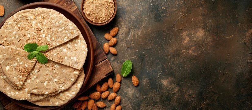 Traditional tahini halva with almonds or Halawa Tahiniya in a Brown baked pitta bread flatbread made mainly in bran Bran breads used for sandwiches and beside meals popular in Egypt selective f