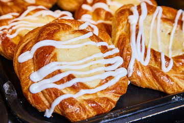 Golden-Brown Danish Pastries with Icing on Baking Tray