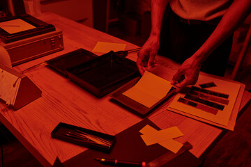 cropped shot of photographer skillfully prepares a film negative for development in darkroom