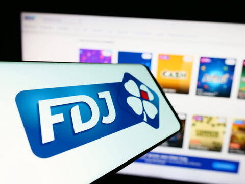 Stuttgart, Germany - 02-13-2024: Mobile phone with logo of French lottery company Francaise des Jeux (FDJ) in front of business website. Focus on center of phone display.