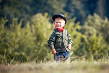 Cute Little Happy Boy with Hat and Bandana in Green Summer Forest - 741650244