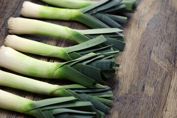 freshly harvested leeks isolated on wooden background
